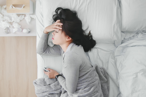 ストレスや緊張で熱を持った頭部を、鍼灸や呼吸法で整える女性のイメージ